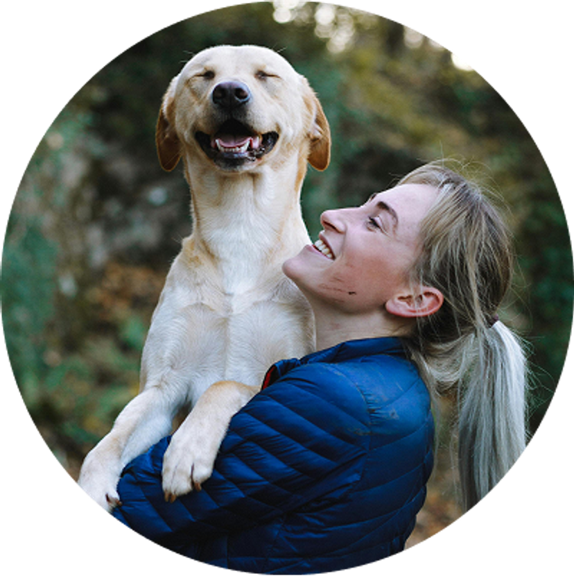 Woman holding a dog who is smiling