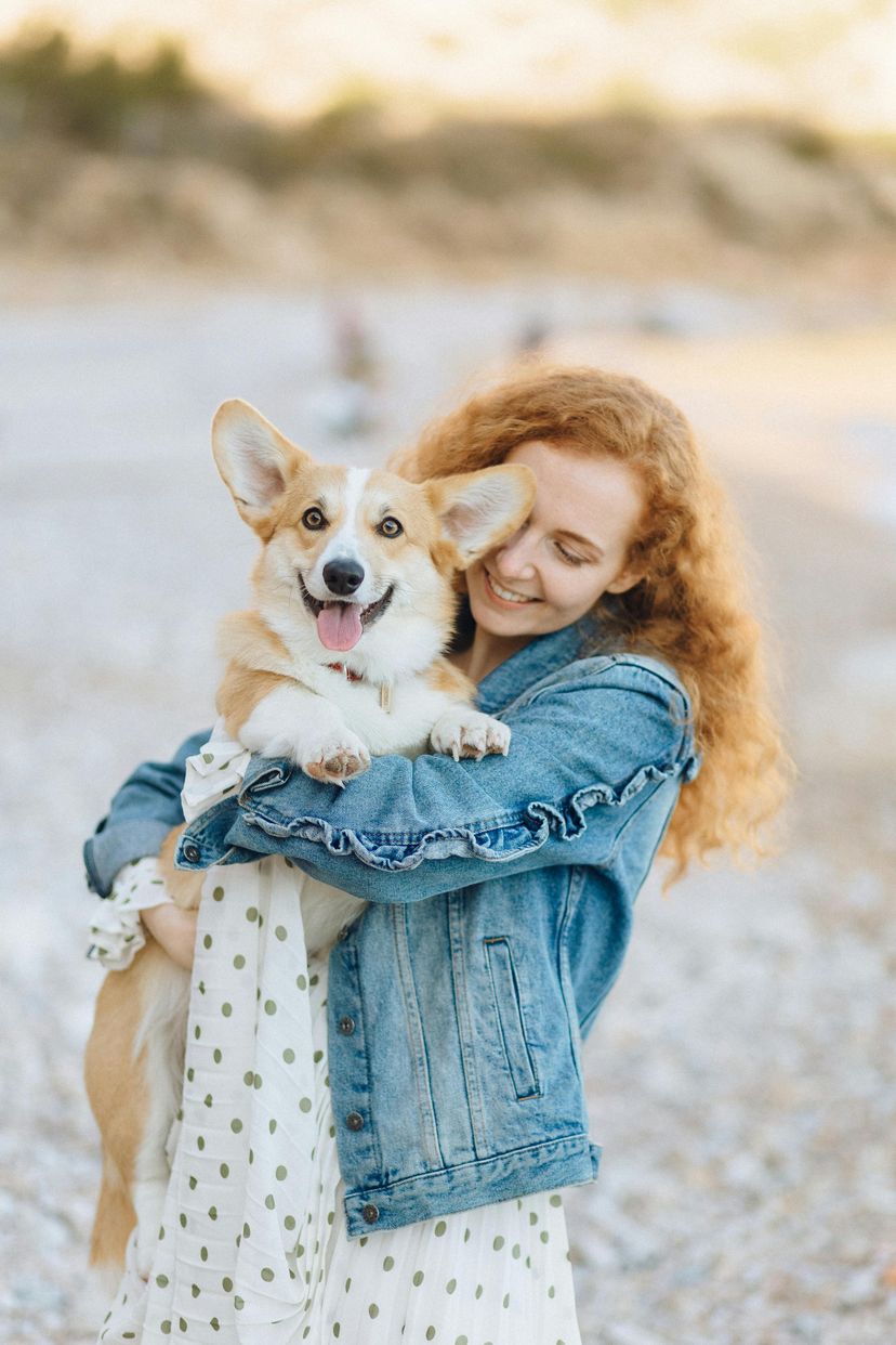 Woman holding dog at the beach