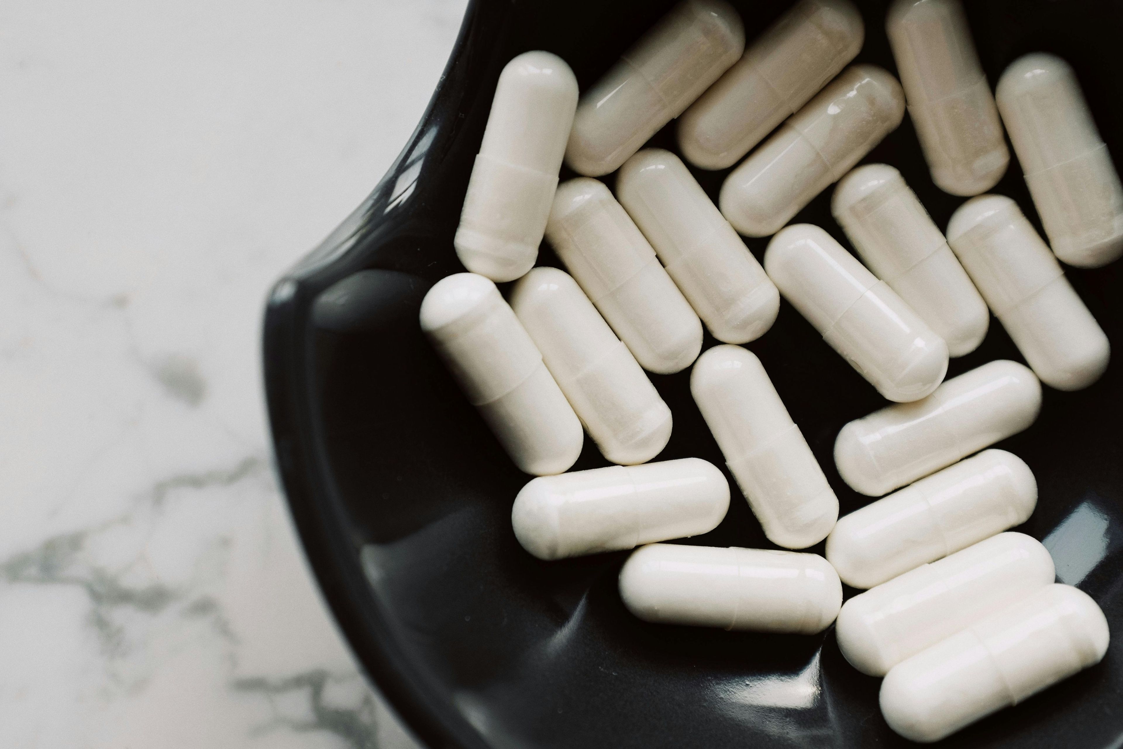 Medication capsules in a black bowl